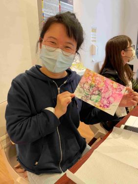 student holding her piece of artwork