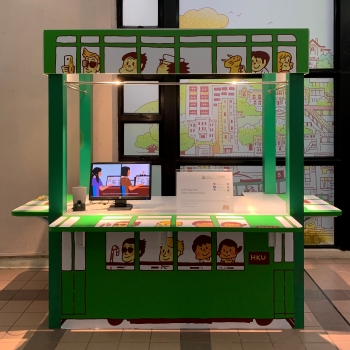 A kiosk decorated with cartoon-style tram windows and passenger to simulate a green Hong Kong tram.