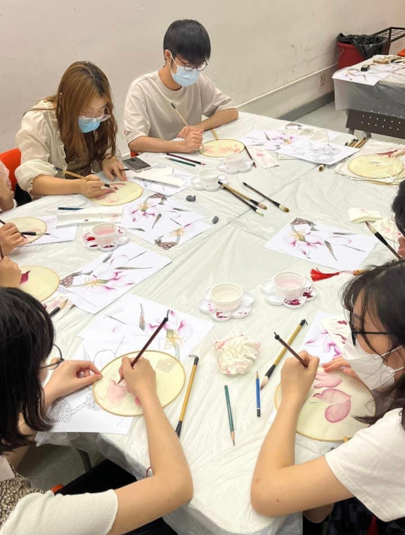 Students are participating in a Chinese Fan Ink Painting Workshop.